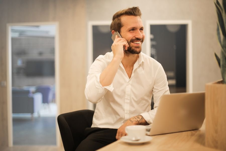 A professional using a mobile app on a phone and laptop