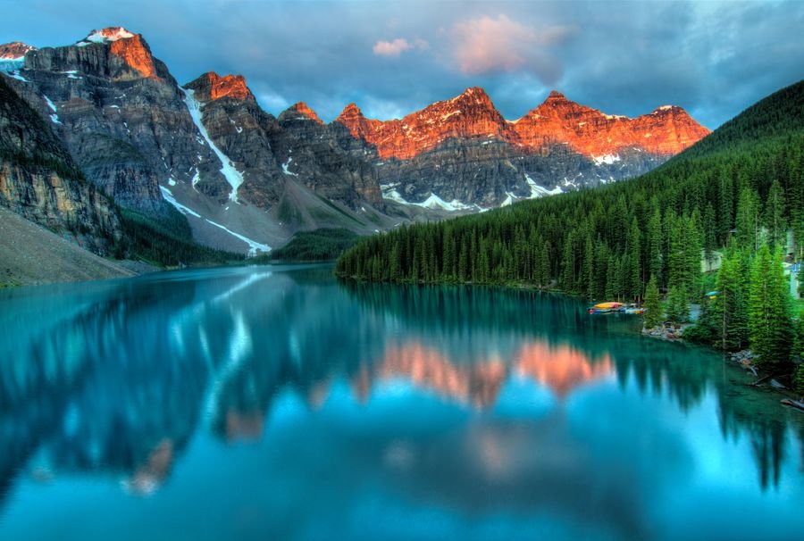 A calm mountain lake and forest at sunrise